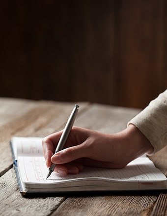 A hand writing in a journal