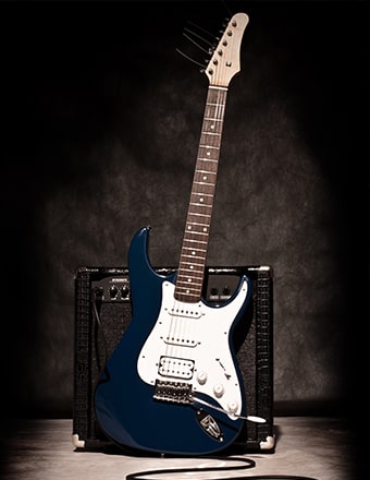 blue guitar leaning against a guitar amp